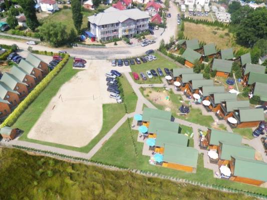 Ośrodek OLEŃKA - obiekt z kategorii domki letniskowe, położony w Sarbinowie, pokazany z perspektywy lotu ptaka.