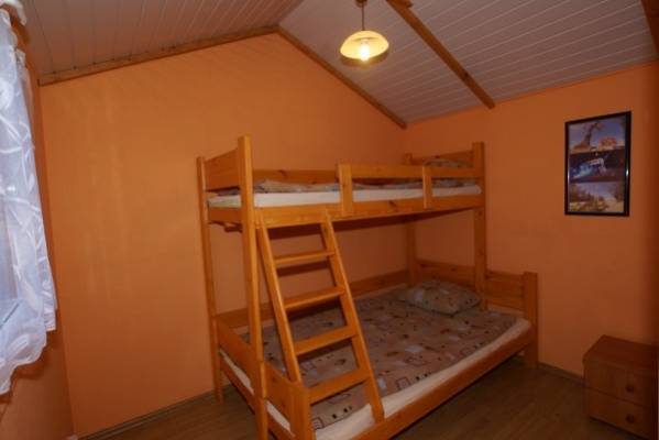 Fotografia przedstawia łóżko w domku letniskowym Domki OSTOJA