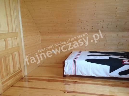 Fotografia przedstawia spanie w pokoju - Bursztynowe Domki | Sarbinowo (wypoczywaj nad morzem) 